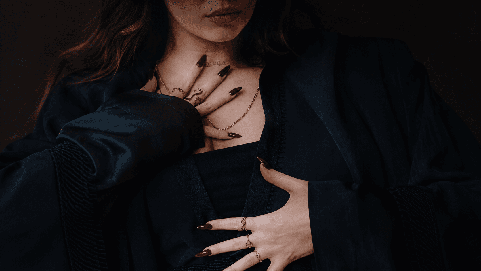 Dancer close-up with dark styling and red nails